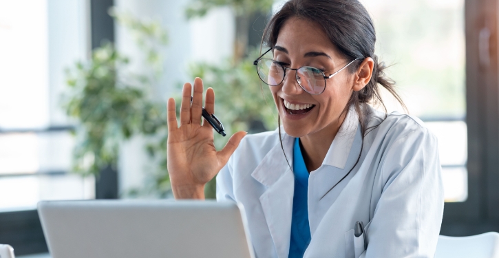 Dentist smiling while viewing laptop